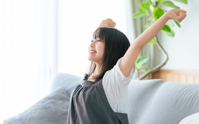 朝の伸びでスッキリとした表情の女性　自律神経が整い心も身体も軽くなる名古屋市中区鶴舞のかんとま整骨院