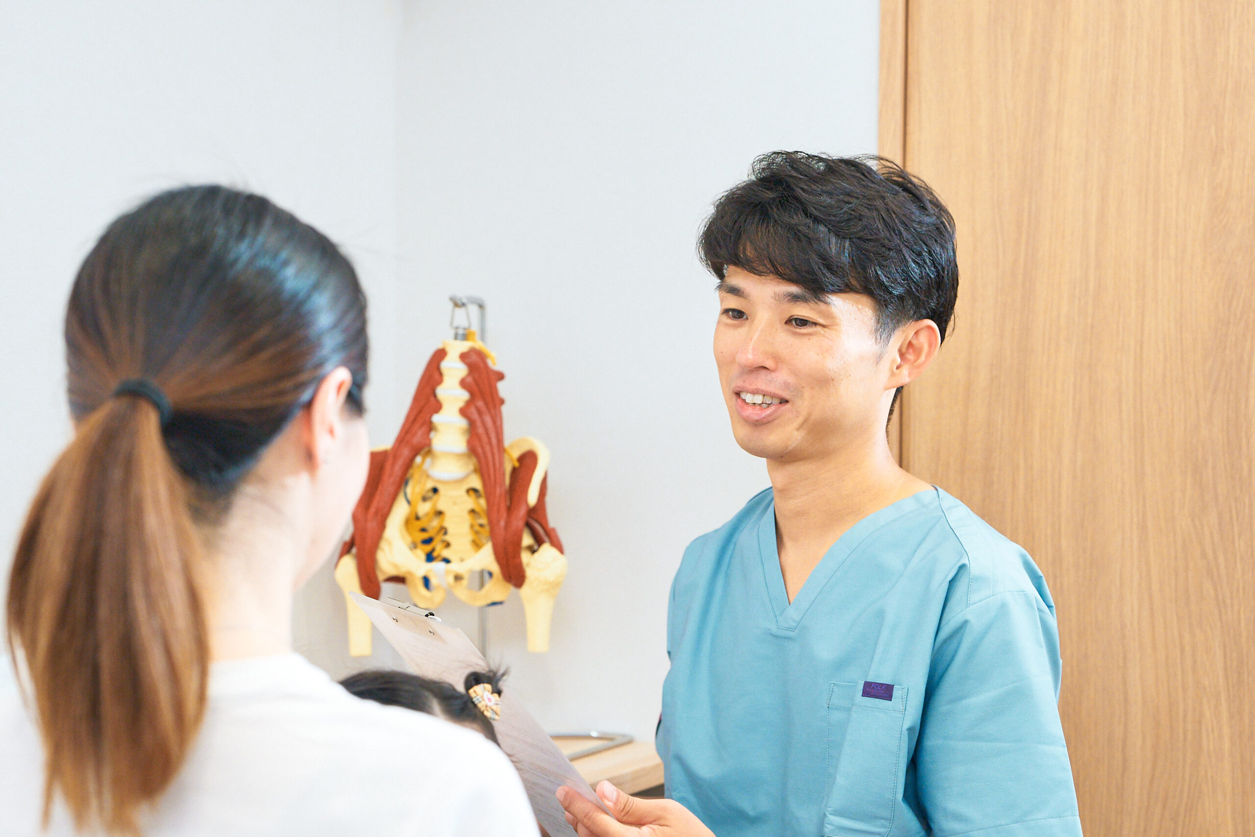 患者さんに寄り添いながら分かりづらい交通事故の対応や、肩こりや腰痛、姿勢や不調の原因を説明する様子　名古屋市中区鶴舞のかんとま整骨院