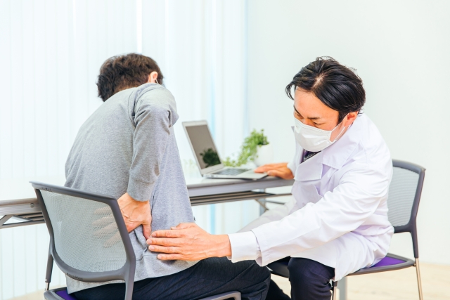 椎間板ヘルニアや坐骨神経痛で腰に痛みを感じている患者の診察イメージ